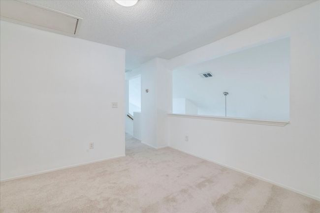 Empty room featuring carpet, a textured ceiling, attic access, and baseboards | Image 24