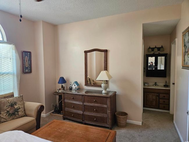 Carpeted bedroom with connected bathroom and a textured ceiling | Image 15
