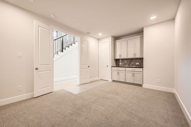 Bar area featuring light carpet, decorative backsplash, recessed lighting, and stairs | Image 26