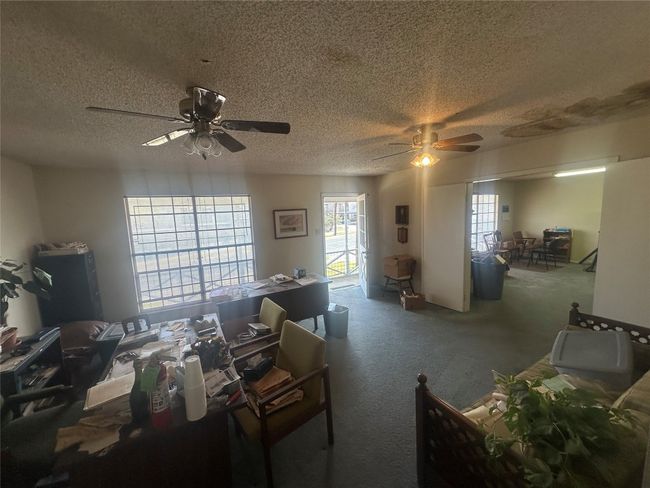 Carpeted living area with ceiling fan and a textured ceiling | Image 18