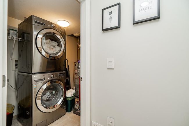 Laundry area with stacked washer / dryer, laundry area, and tile patterned flooring | Image 26