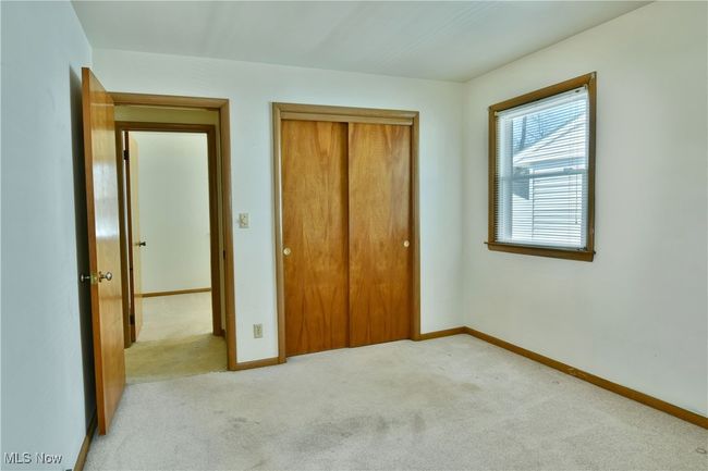 Unfurnished bedroom with light colored carpet, baseboards, and a closet | Image 25