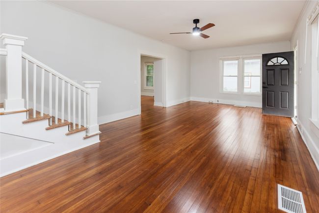 living room featuring a ceiling fan, wood-type flooring, stairs, baseboards, and ornamental molding | Image 35