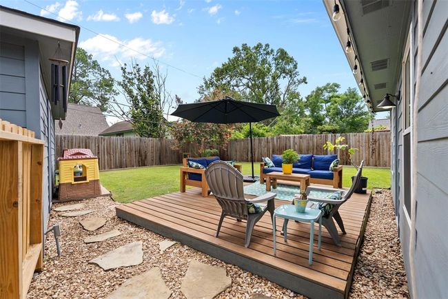 Cozy backyard with a wooden deck, perfect for relaxing or entertaining. | Image 23