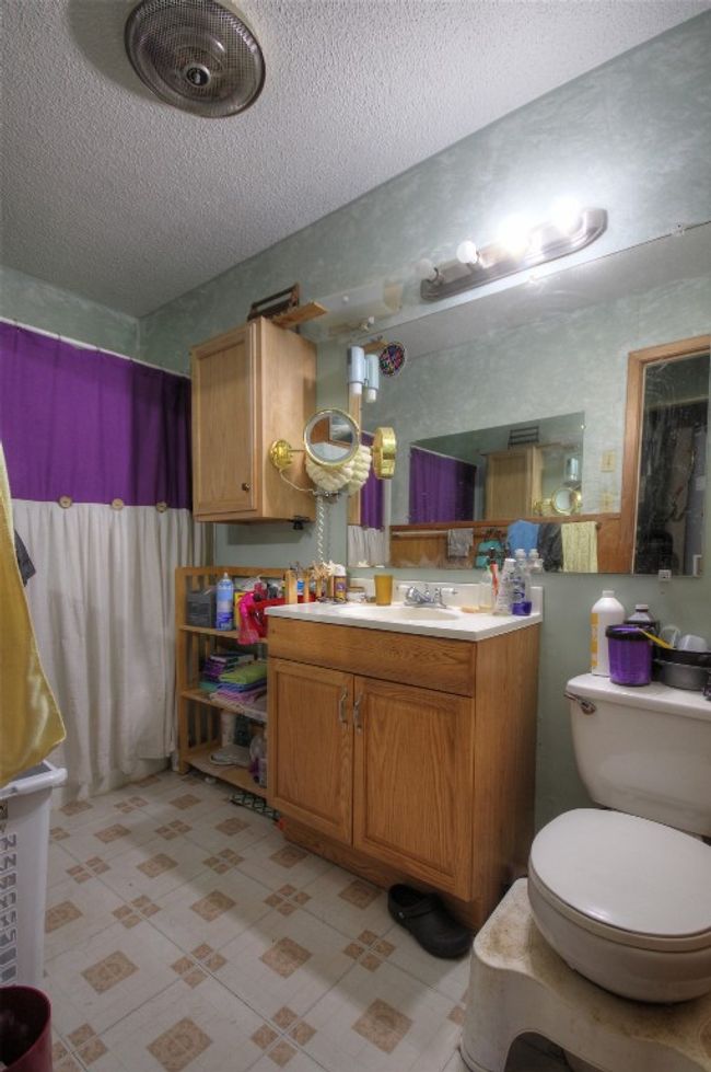 Full bathroom with vanity, a textured ceiling, and toilet | Image 8