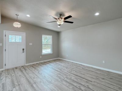 Foyer entrance featuring light wood-type flooring, ceiling fan, vaulted ceiling, and a textured ceiling | Image 3