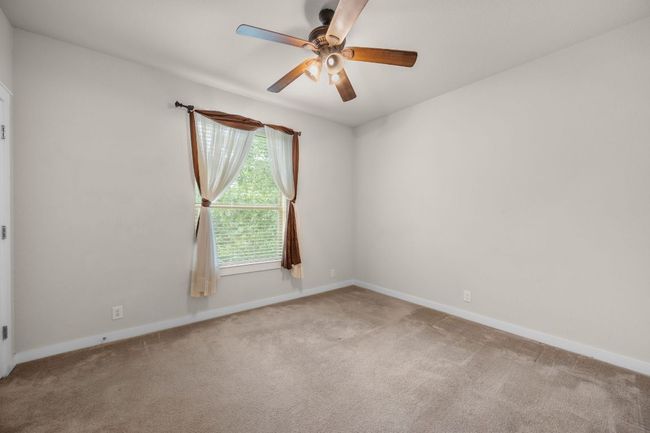 Carpeted empty room with a ceiling fan and baseboards | Image 21
