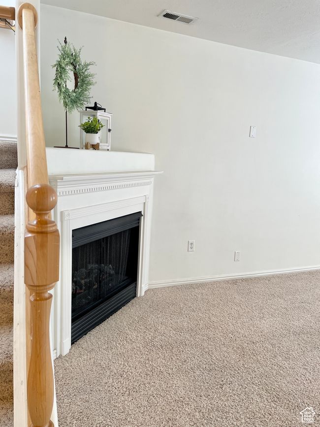 Unfurnished living room featuring carpet floors, a fireplace, and baseboards | Image 4