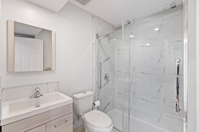 Bathroom with a marble finish shower, vanity, and toilet | Image 22