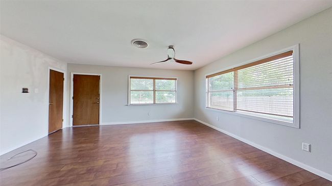 Unfurnished room with a ceiling fan, wood finished floors, and baseboards | Image 8