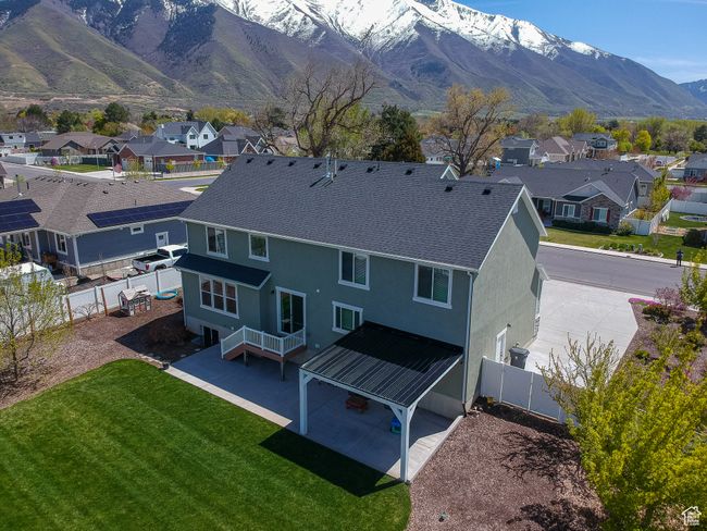 Back of house with a residential view, a fenced backyard, a mountain view, a yard, and stucco siding | Image 55