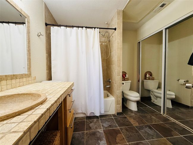 Bathroom with visible vents, vanity, shower / bath combination with curtain, and toilet | Image 16