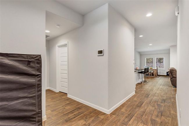 Spacious foyer. On right not seen is 2 bedrooms and a full bath. Ahead is kitchen living and dining and not seen on left past dining is Primary bedroom. Left is garage, laundry and an additional bedroom | Image 10