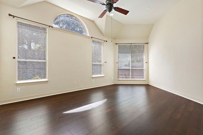 Empty room with vaulted ceiling, a ceiling fan, hardwood / wood-style floors, and baseboards | Image 17