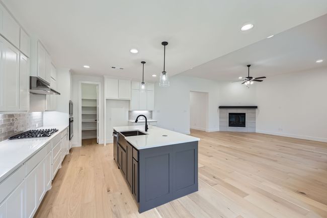 Kitchen featuring recessed lighting, under cabinet range hood, ceiling fan, white cabinets, and appliances with stainless steel finishes | Image 8