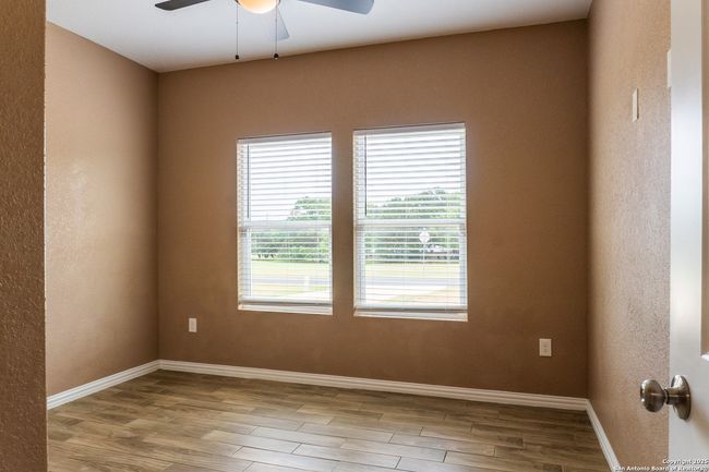 Sunlit bedroom with ceiling fan overhead | Image 21