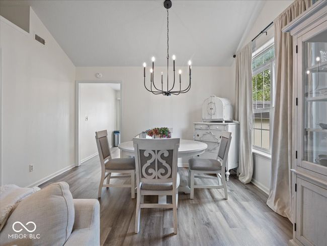 dining room has wood finished floors, an inviting chandelier, and vaulted ceiling & lots of natural light | Image 8