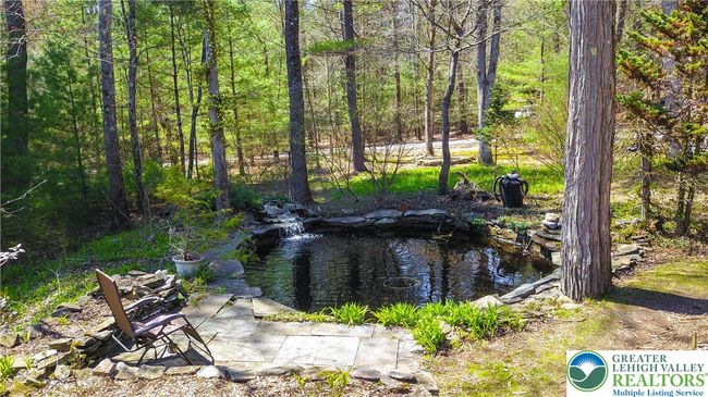 You are Greeted by the sound of the house pond with waterfalls and Patio | Image 5