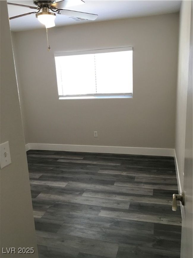 Empty room featuring a wealth of natural light, a ceiling fan, dark wood finished floors, and baseboards | Image 28