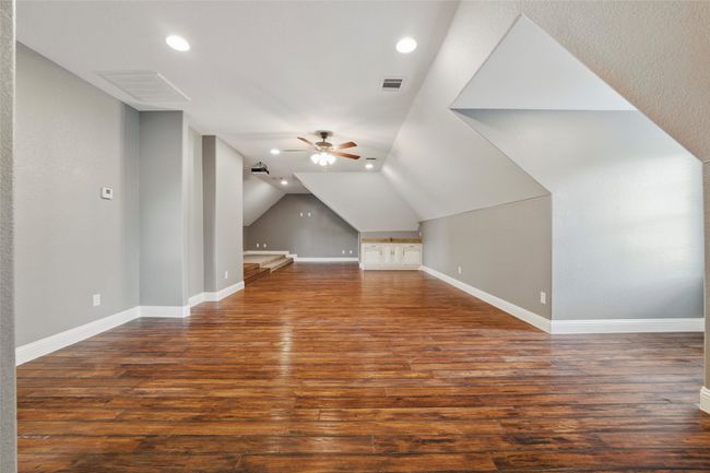 Additional living space with wood finished floors, a ceiling fan, baseboards, recessed lighting, and lofted ceiling | Image 22