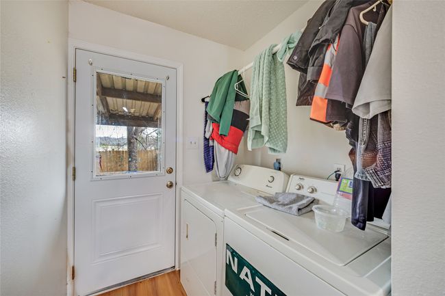 Unit A Laundry area featuring washer and clothes dryer and light hardwood / wood-style flooring | Image 34