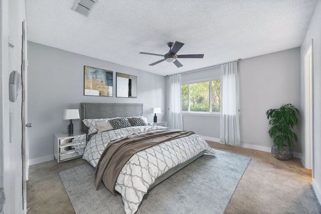 Bedroom featuring concrete flooring, a textured ceiling, and a ceiling fan | Image 12