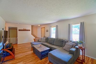 Living room with light hardwood / wood-style floors and a textured ceiling | Image 2