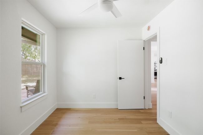 Empty room featuring a ceiling fan, light wood finished floors, and a smoke detector | Image 26