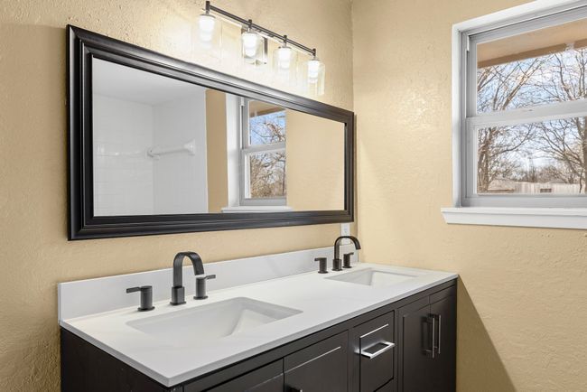 Bathroom with double vanity, a sink, and a textured wall | Image 19