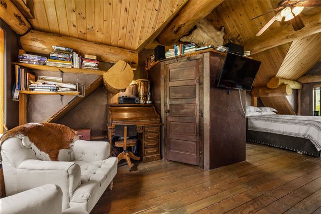 Bedroom with wood-type flooring, rustic walls, and wood ceiling | Image 23