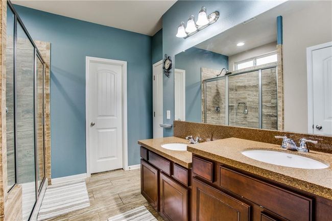 Full bathroom with a shower stall, double vanity, and wood finished floors | Image 14