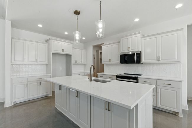 Kitchen with appliances with stainless steel finishes, a sink, recessed lighting, finished concrete flooring, and decorative backsplash | Image 5