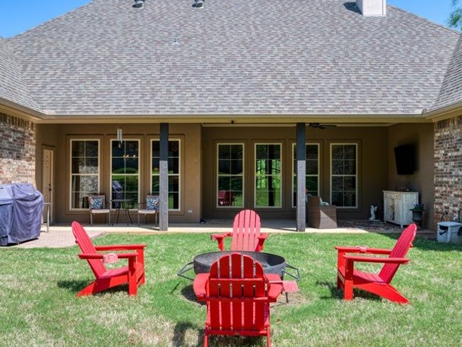 Back of property with a shingled roof, an outdoor fire pit, a yard, and a patio | Image 35