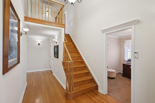 Staircase with wood-type flooring, baseboard heating, baseboards, and ornamental molding | Image 36