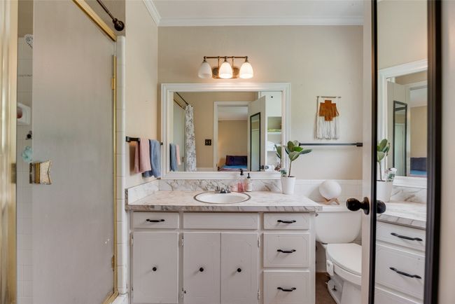 Ensuite bathroom with crown molding, vanity, toilet, connected bathroom, and a shower with door | Image 18