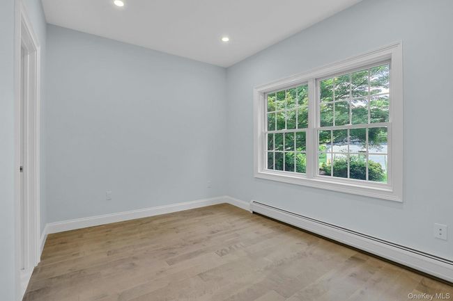 Empty room with a baseboard radiator, recessed lighting, and light wood finished floors | Image 14