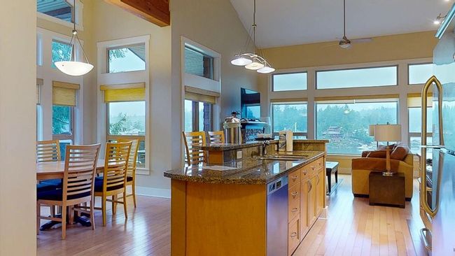 Kitchen featuring high vaulted ceiling, a kitchen island with sink, light wood-style flooring, a sink, and dishwasher | Image 6