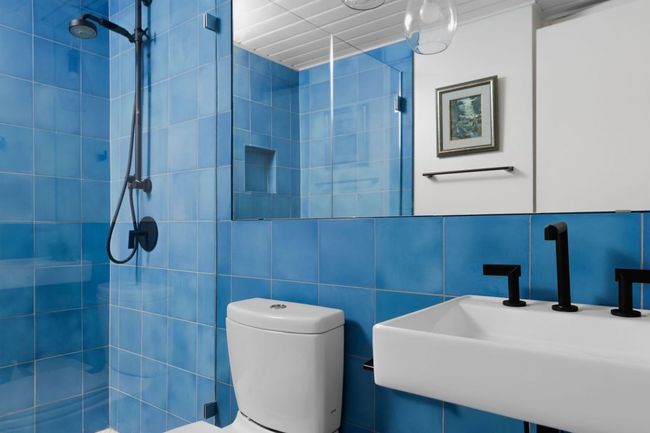 Full bathroom with tile walls, a sink, toilet, and tiled shower | Image 10
