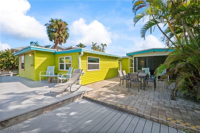 Back of house with a wooden deck, a sunroom, and a patio area | Image 44