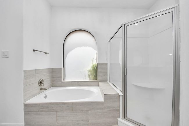 Primary bathroom has separate garden tub and shower | Image 18