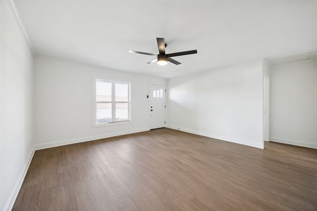 Spare room featuring ceiling fan, ornamental molding, and dark wood finished floors | Image 6