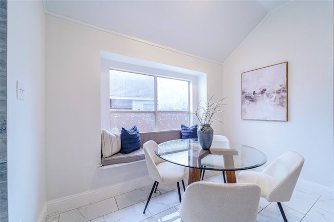 Dining room with light marble finish flooring and lofted ceiling | Image 10