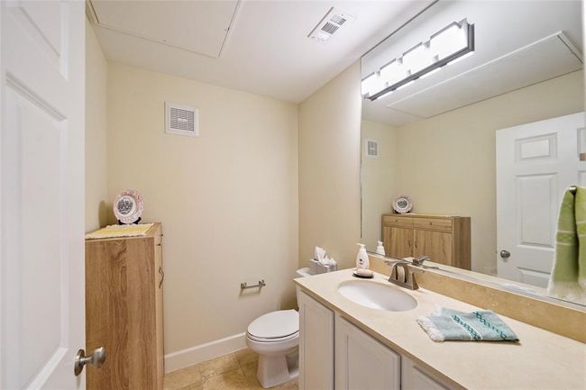 Chic and functional powder room featuring modern fixtures and ample storage. Perfect for guests. | Image 5