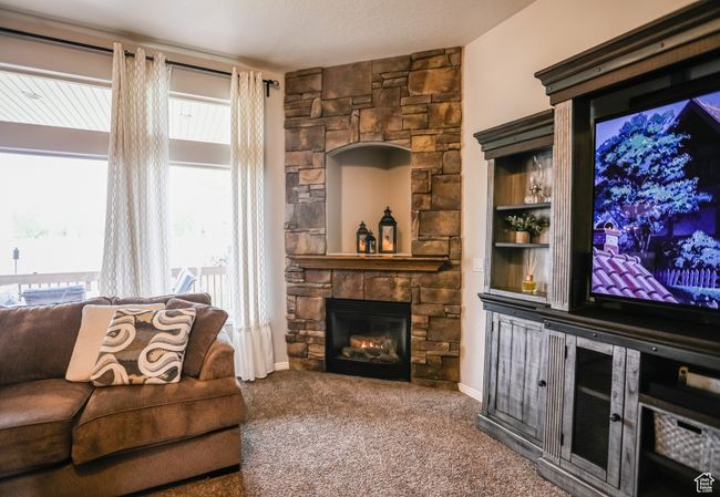 Carpeted living area with a fireplace | Image 13