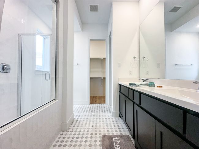 Full bathroom with a shower stall, double vanity, a walk in closet, and tile patterned floors | Image 20
