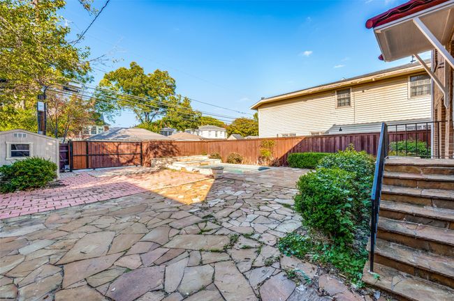 Fenced backyard with a patio area | Image 32