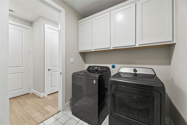 The utility room offers built-in cabinets for household storage, washer connections, and both gas and electric dryer connections. | Image 34