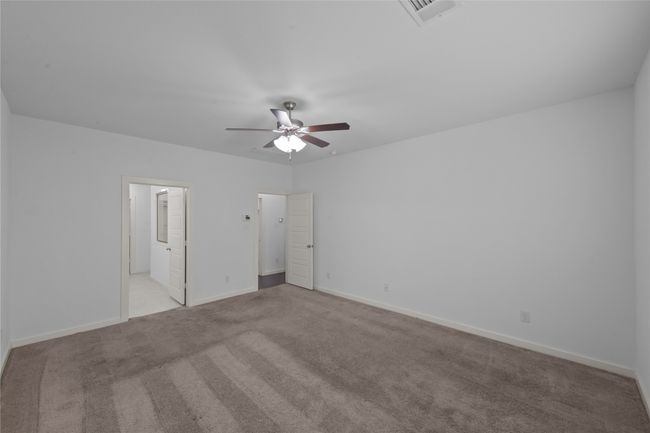 Unfurnished bedroom with carpet, ensuite bathroom, and ceiling fan | Image 26