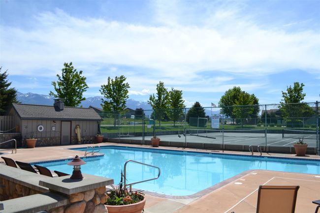 Community pool with fence, a mountain view, and a tennis court | Image 15
