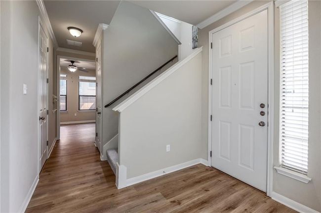Entryway with crown molding, wood finished floors, stairway, and a ceiling fan | Image 20